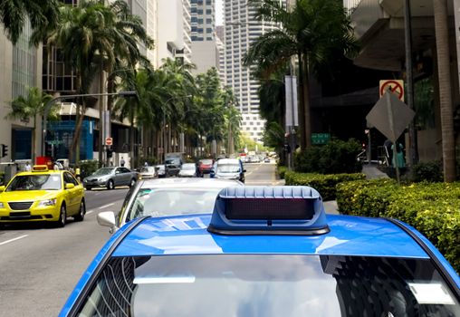 Taxi in the central sreet in Singapore. Sharpness on a blue car