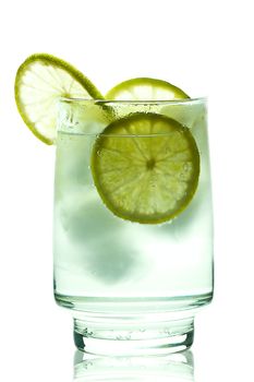 Glass of gin and tonic with ice cubes and lime slices. isolated on white