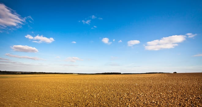 Beautiful wide angle image of a freshly tilled field in the UK on a crisp autumn day, could be used as a template with plenty of copyspace