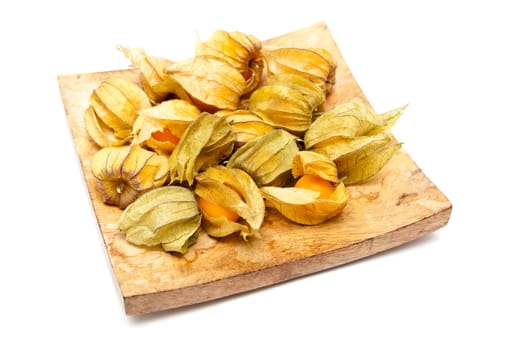 Physalis fruits on a wooden dish on white background