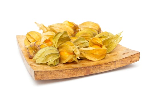 Physalis fruits on a wooden dish on white background