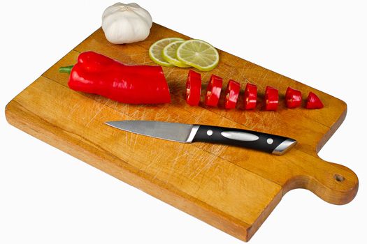 Chopping Board with pepper. lime, garlic and knife isolated on white