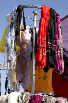 Headscarf cloak and decorative colored scarves sold at market street fair.