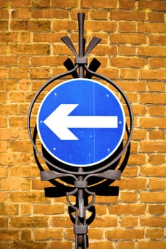 Beautiful vintage toned image of a one way sign against a brick wall in the UK