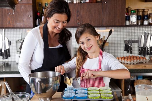 Mother and daughter making cupcakes in the kitchen