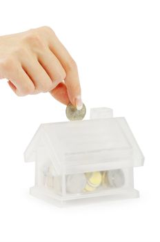 Hand with coin and house bank isolated on white background