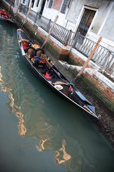 Urban scene in Venice, Italy. Empty gondola near dwelling house on a canal