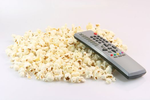 television remote control over pop corn food and entertainment conceps