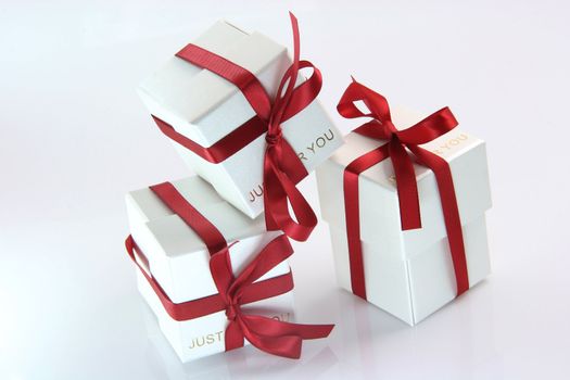 three white gift boxes with red ribbon for valentines day and love gifts