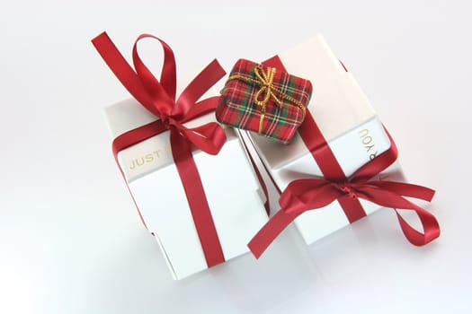 one small tiny gift box with two white gift boxes with red ribbon for valentines day and love gifts shopping concepts