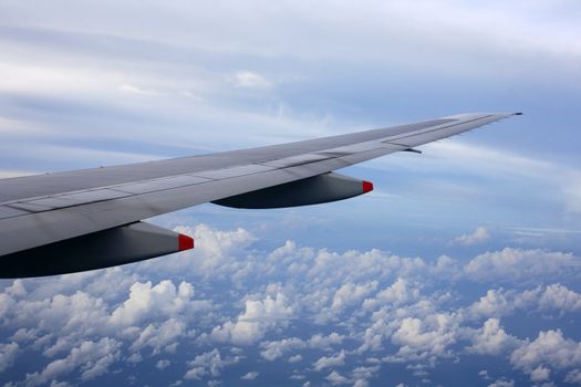Wing of the plane on a background of clouds