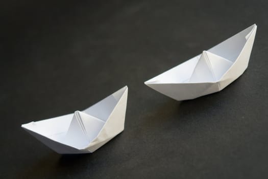 Paper boats - simple origami on a black background