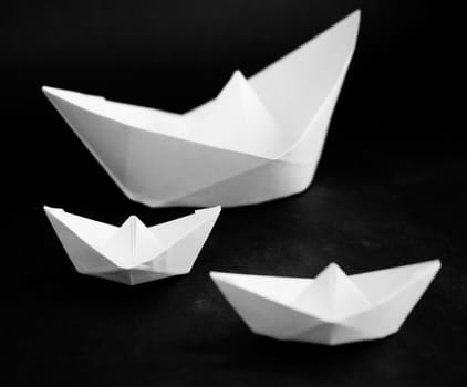 Paper boats - simple origami on a black background