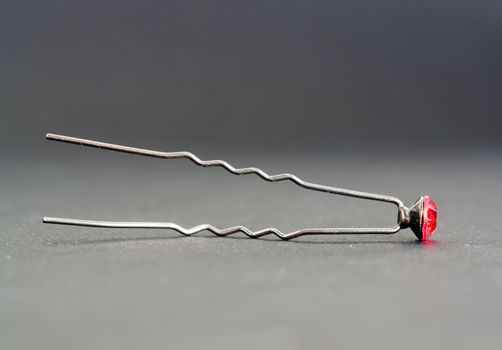 Hairpin with a ruby on a grey background