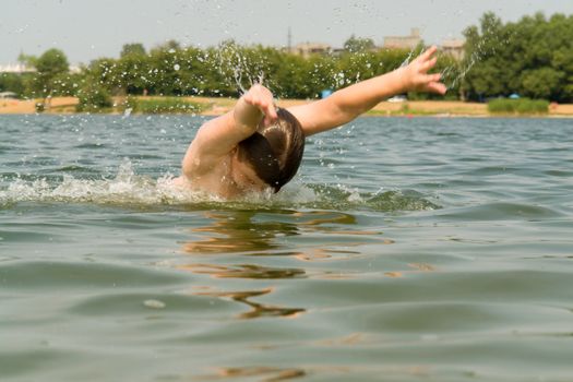 the little boy quickly swims the butterfly stroke