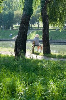 old woman has a rest in park near the river