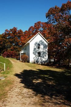 An old white house during the fall of the year