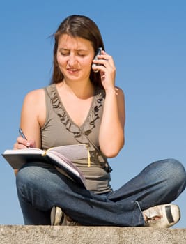 beautiful girl taking notes on a sky background