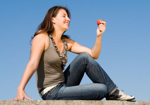 beautiful girl with red peach on a blue sky