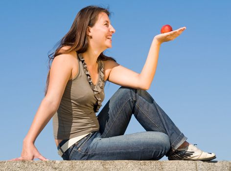 beautiful girl with red peach on a blue sky