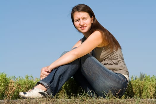 beautiful girl sits on a blue sky