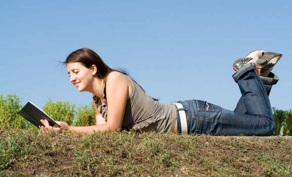 girl reads book with sky at background