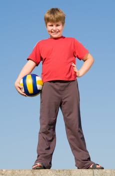 little boy with volleyball ball on a blue sky