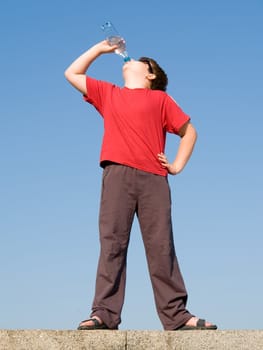 boy drinks water on a blue sky