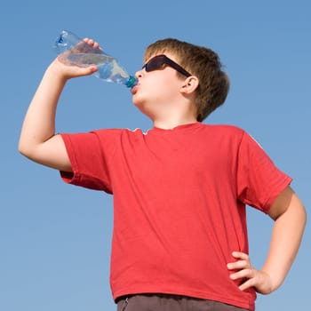 boy drinks water on a blue sky