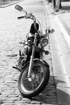 motorcycle is parked on a stone paving