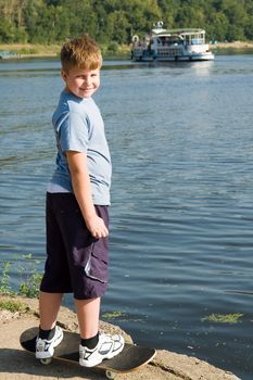 boy on a skateboard with river at background