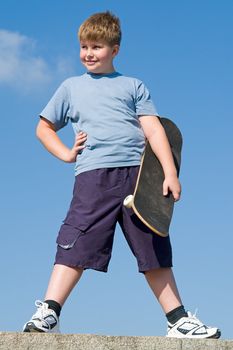 boy with skateboard on a blue sky