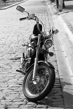 motorcycle is parked on a stone paving