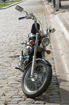 motorcycle is parked on a stone paving