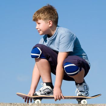 boy with skateboard on a blue sky