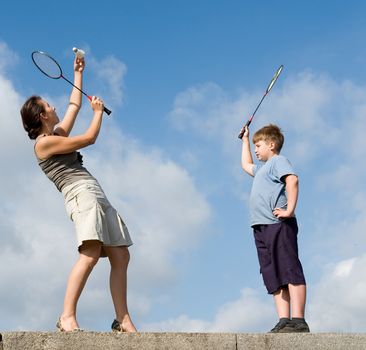 Family playing badminton on a blue sky