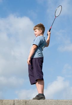 little boy playing badminton on a blue sky