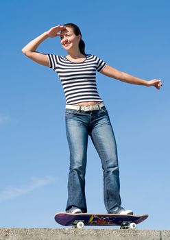 girl on a skateboard with blue sky at background