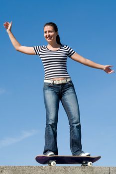 girl on a skateboard with blue sky at background