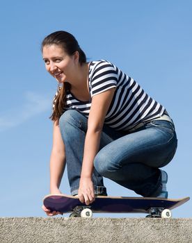 girl on a skateboard with blue sky at background