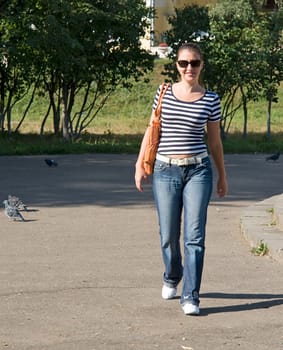 Walk. The young woman walks in park.