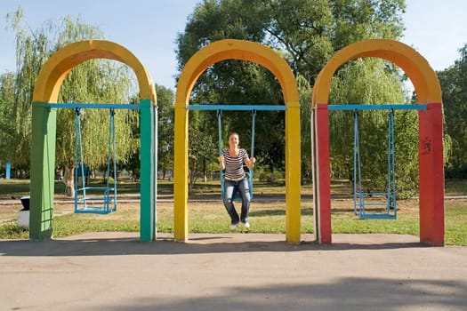 girl on a swing in city park