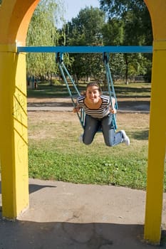 girl on a swing in city park