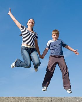 jumping family. Mum and the son with blue sky at background