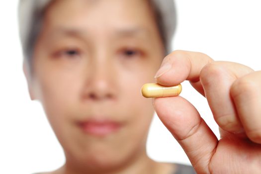 mature woman holding pill