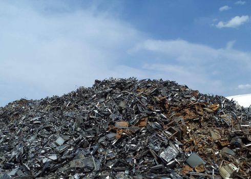 Stack of Metal Garbage in front of blue sky