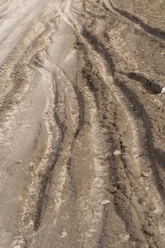 Traces of car tyres on the wet fields road