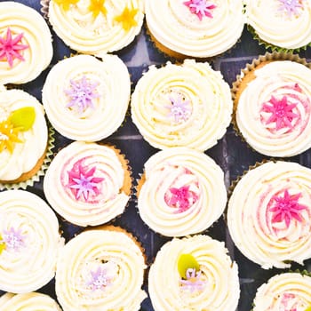 Background image of s selection of decorated cupcakes