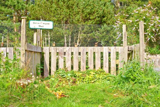 A compost heap in a lush green garden in summer time