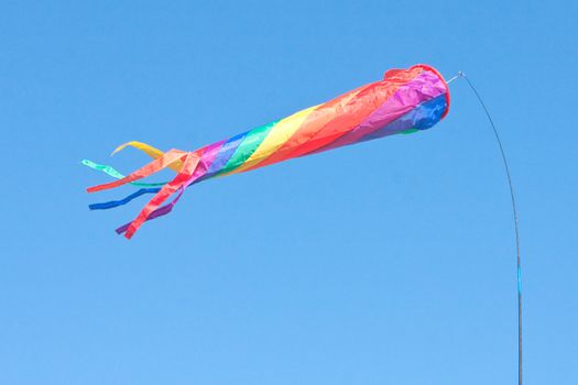 A colorful toy flag or windsock blowing on a sunny summer day